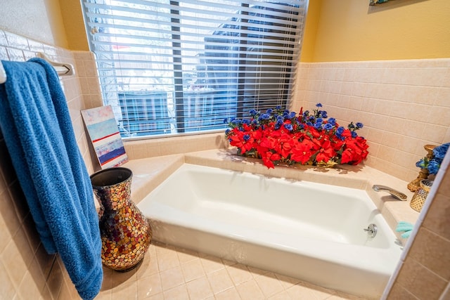 bathroom featuring a bath, tile patterned floors, and tile walls