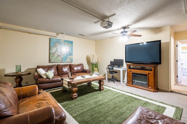 living room featuring ceiling fan, carpet floors, and a textured ceiling