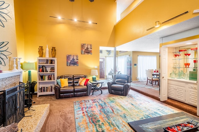 carpeted living room featuring rail lighting and a high ceiling