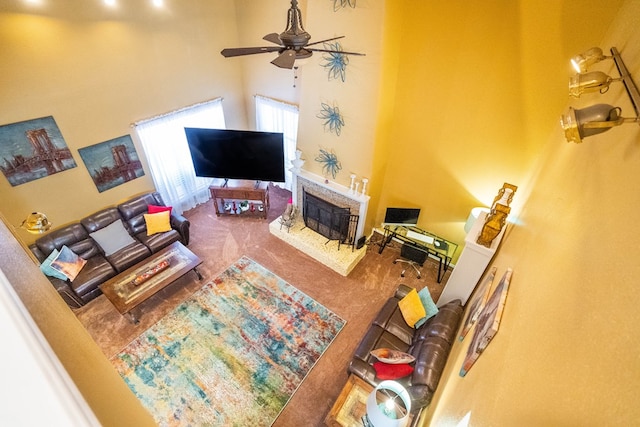 carpeted living room featuring ceiling fan and a brick fireplace