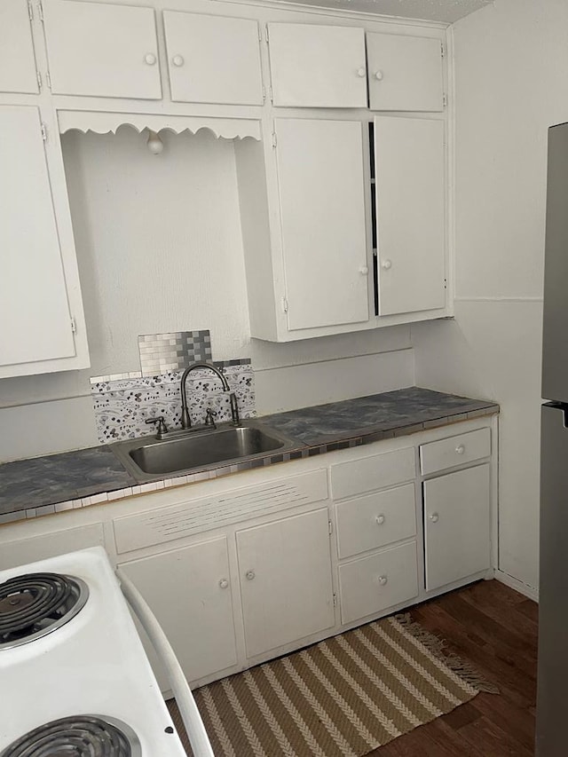 305 S Jackson Ave, Midland, TX 79701 - kitchen featuring white cabinets, wood finished floors, tile counters, and freestanding refrigerator