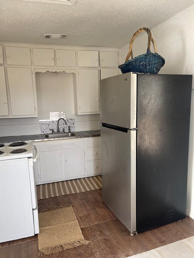 305 S Jackson Ave, Midland, TX 79701 - kitchen featuring freestanding refrigerator, electric stove, white cabinetry, dark wood finished floors, and a textured ceiling