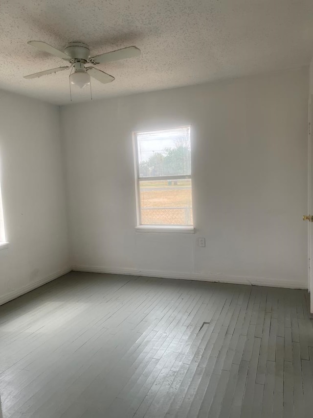 305 S Jackson Ave, Midland, TX 79701 - empty room with healthy amount of natural light, a ceiling fan, wood finished floors, and a textured ceiling