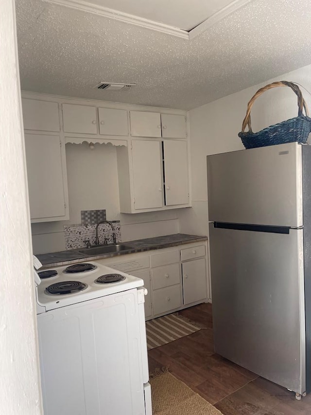 305 S Jackson Ave, Midland, TX 79701 - kitchen featuring freestanding refrigerator, electric stove, white cabinetry, wood finished floors, and dark countertops