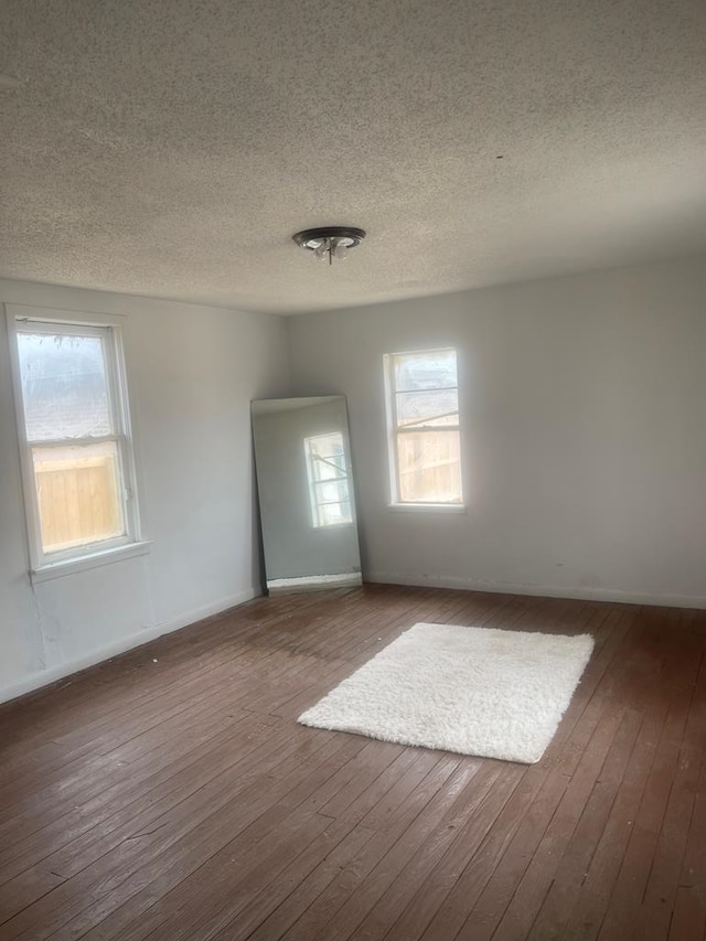 305 S Jackson Ave, Midland, TX 79701 - spare room featuring hardwood / wood-style floors, a textured ceiling, and healthy amount of natural light