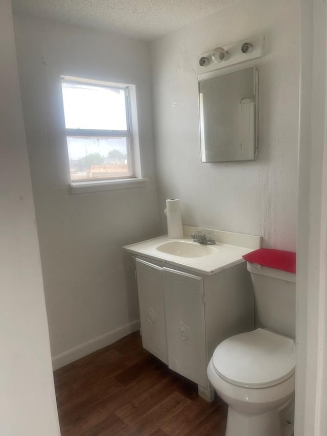 305 S Jackson Ave, Midland, TX 79701 - half bath featuring vanity, wood finished floors, and a textured ceiling