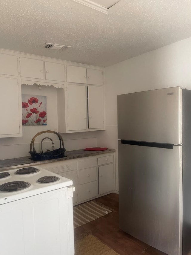 305 S Jackson Ave, Midland, TX 79701 - kitchen featuring freestanding refrigerator, dark wood-style flooring, white cabinets, white electric range oven, and a textured ceiling