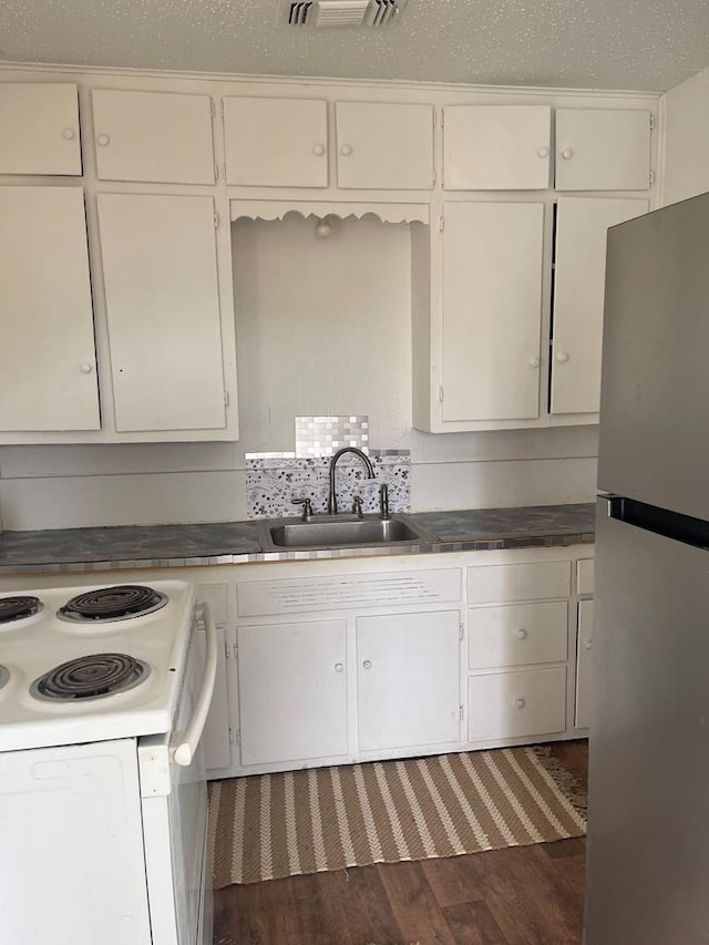 305 S Jackson Ave, Midland, TX 79701 - kitchen with freestanding refrigerator, dark wood-type flooring, white cabinets, and white electric range oven