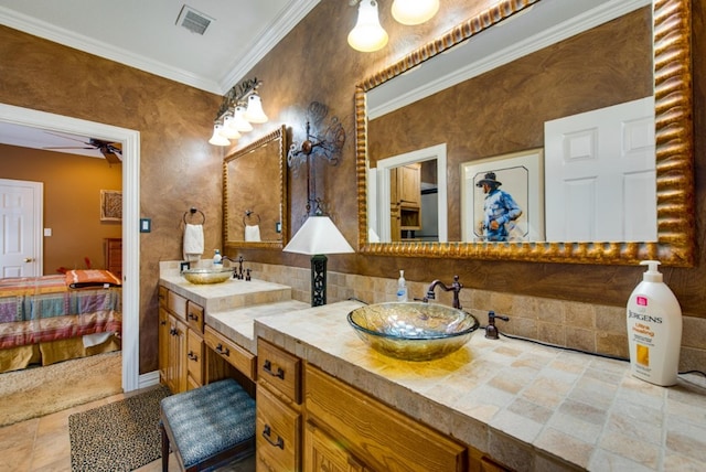 ensuite bathroom featuring crown molding, connected bathroom, visible vents, and a sink