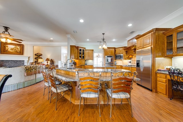 kitchen featuring stone countertops, a fireplace, brown cabinetry, and built in appliances