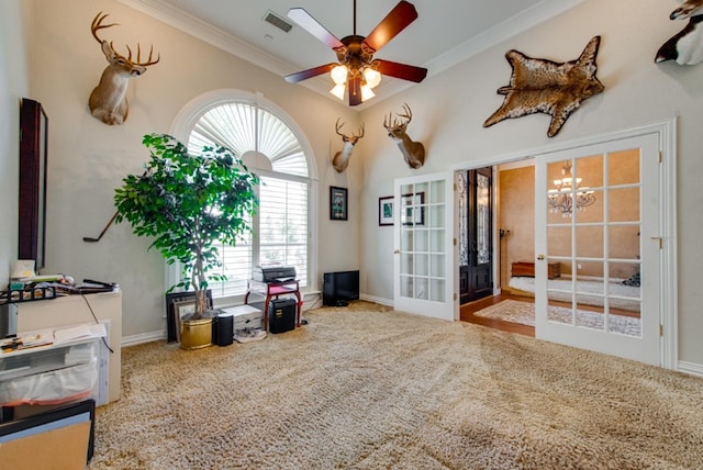 sitting room with carpet, french doors, crown molding, and ceiling fan with notable chandelier