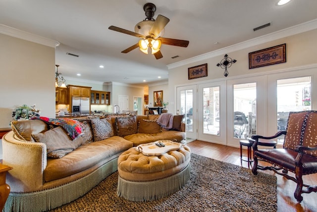 living area featuring ornamental molding and visible vents