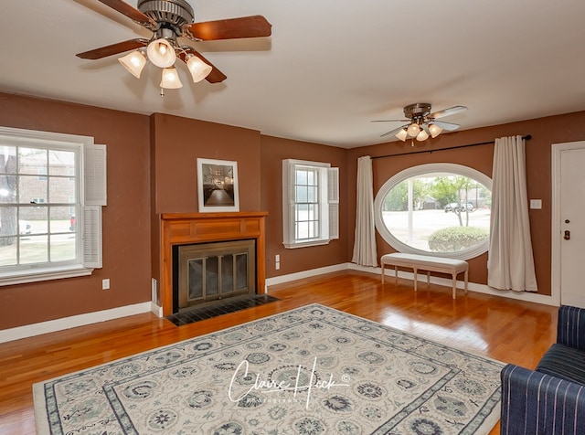 1700 Holloway Ave, Midland, TX 79701 - unfurnished living room with ceiling fan, wood finished floors, and a fireplace with flush hearth