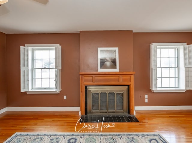1700 Holloway Ave, Midland, TX 79701 - unfurnished living room with a fireplace with flush hearth, wood finished floors, and plenty of natural light