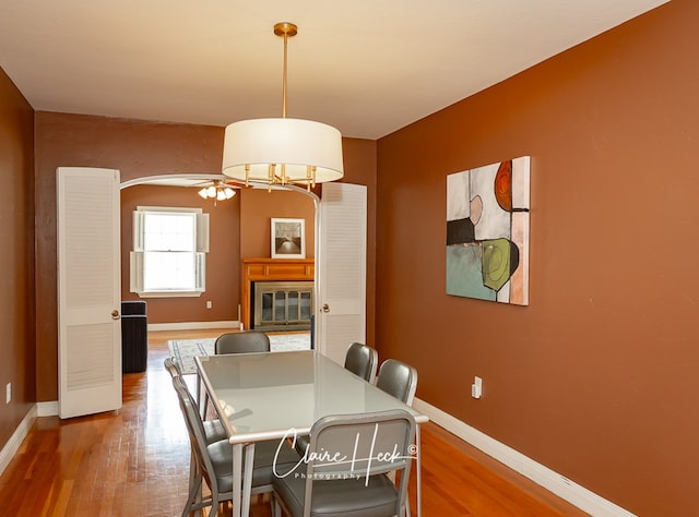 1700 Holloway Ave, Midland, TX 79701 - dining area featuring wood finished floors, a ceiling fan, and a glass covered fireplace