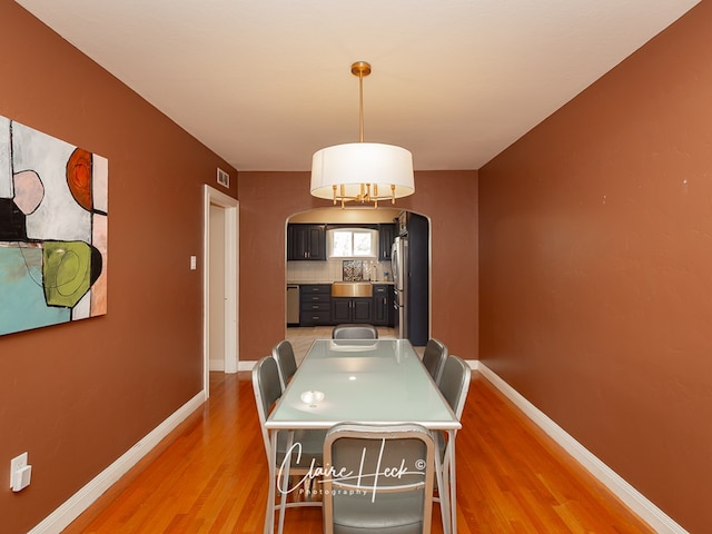 1700 Holloway Ave, Midland, TX 79701 - dining room featuring light wood-type flooring and arched walkways