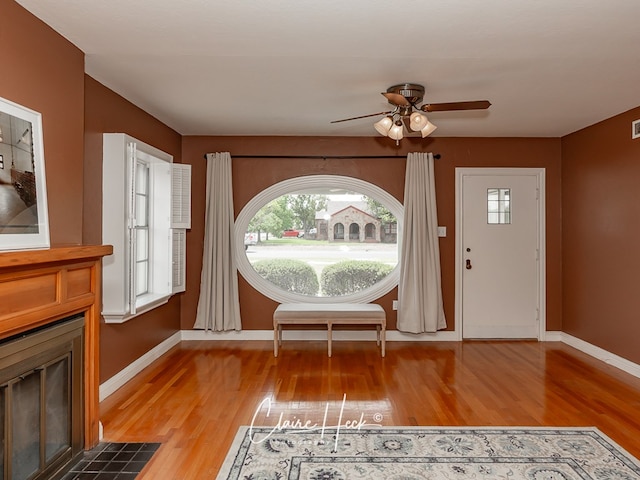 1700 Holloway Ave, Midland, TX 79701 - entryway with light wood-style flooring, a ceiling fan, and a fireplace with flush hearth