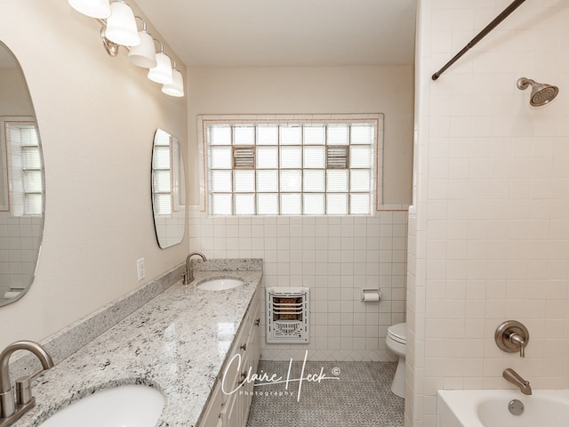 1700 Holloway Ave, Midland, TX 79701 - full bath featuring heating unit, tile patterned flooring, double vanity, tile walls, and shower / bathtub combination