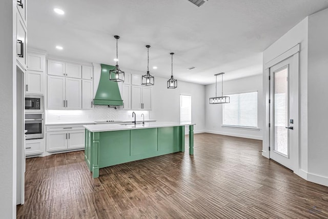 2200 S County Rd 1059, Midland, TX 79706 - kitchen with a sink, custom exhaust hood, white cabinetry, light countertops, and stainless steel oven