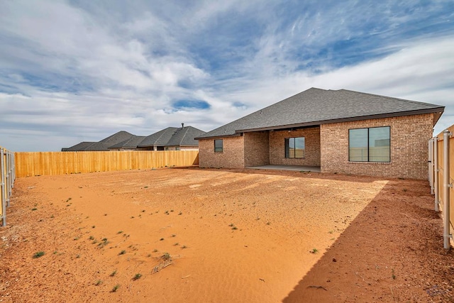 2200 S County Rd 1059, Midland, TX 79706 - back of house featuring brick siding, a fenced backyard, and a shingled roof