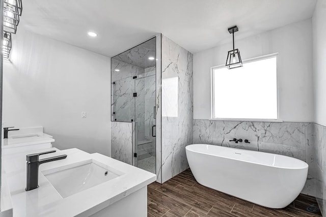 2200 S County Rd 1059, Midland, TX 79706 - full bathroom with tile walls, vanity, a marble finish shower, a soaking tub, and wood finished floors