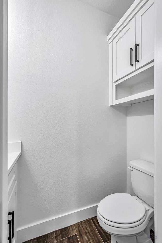 2200 S County Rd 1059, Midland, TX 79706 - bathroom with baseboards, wood finished floors, toilet, and vanity