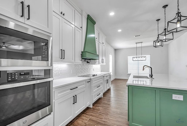 2200 S County Rd 1059, Midland, TX 79706 - kitchen with a sink, light countertops, premium range hood, built in microwave, and stainless steel oven