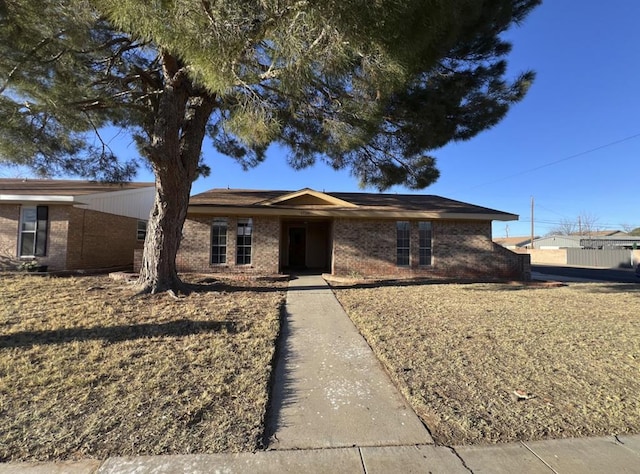 single story home featuring brick siding