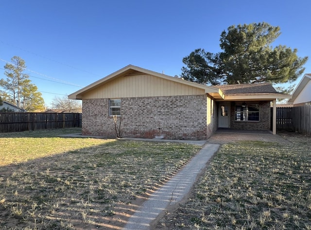 rear view of property with brick siding, a lawn, a patio area, and a fenced backyard