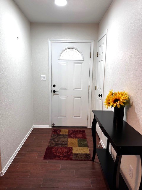 entryway with dark hardwood / wood-style flooring