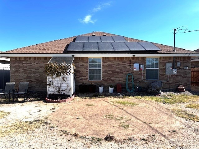 rear view of house featuring solar panels