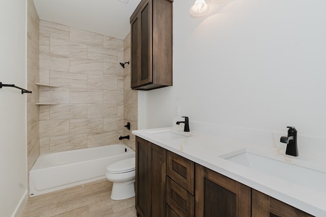 full bathroom with hardwood / wood-style floors, vanity, toilet, and tiled shower / bath