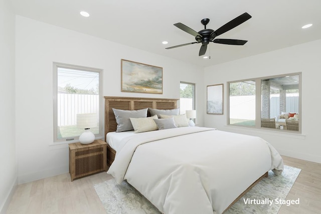 bedroom featuring multiple windows, ceiling fan, and light wood-type flooring