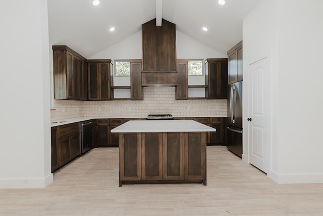 kitchen featuring appliances with stainless steel finishes, dark brown cabinetry, light hardwood / wood-style floors, and a kitchen island