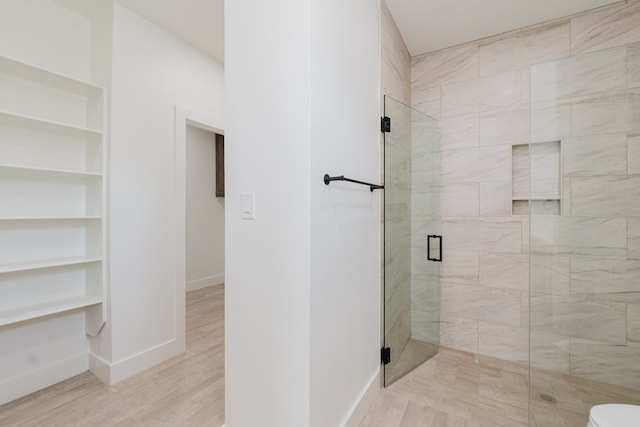 bathroom with hardwood / wood-style floors, toilet, and walk in shower