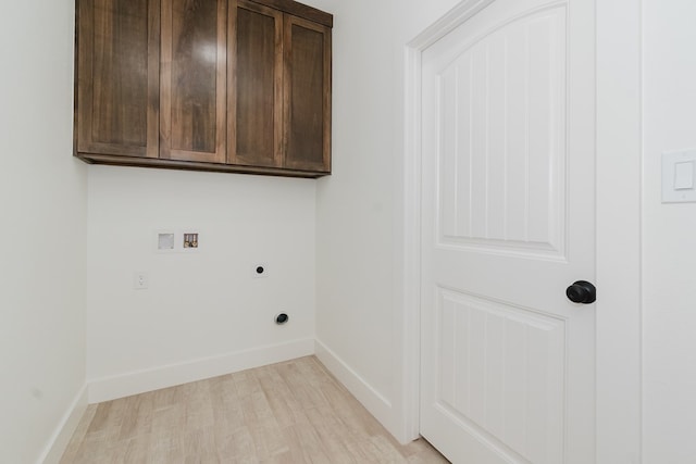 laundry area featuring electric dryer hookup, cabinets, hookup for a washing machine, and light hardwood / wood-style floors