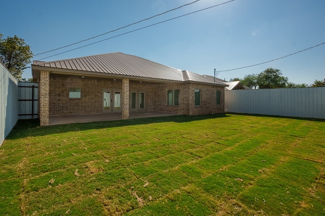 back of house with a yard and a patio