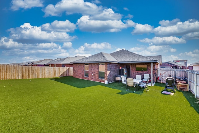 1109 Cajun St, Odessa, TX 79765 - rear view of house with a fenced backyard, brick siding, and roof with shingles
