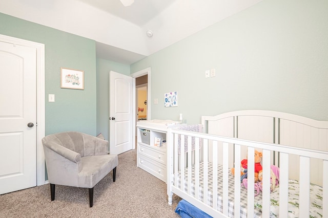 bedroom featuring a nursery area and light carpet