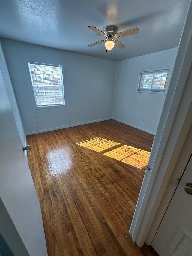 unfurnished room with ceiling fan and wood-type flooring