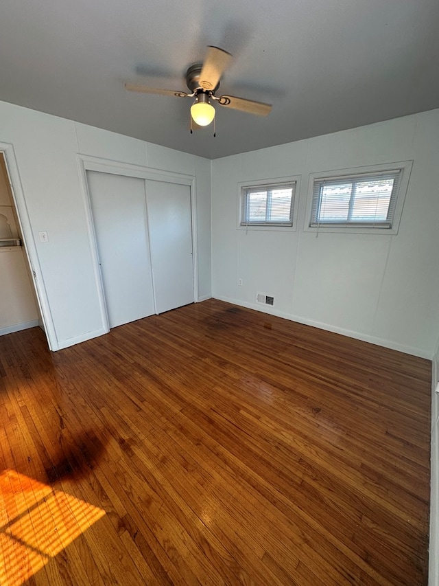 unfurnished bedroom featuring dark hardwood / wood-style floors and ceiling fan