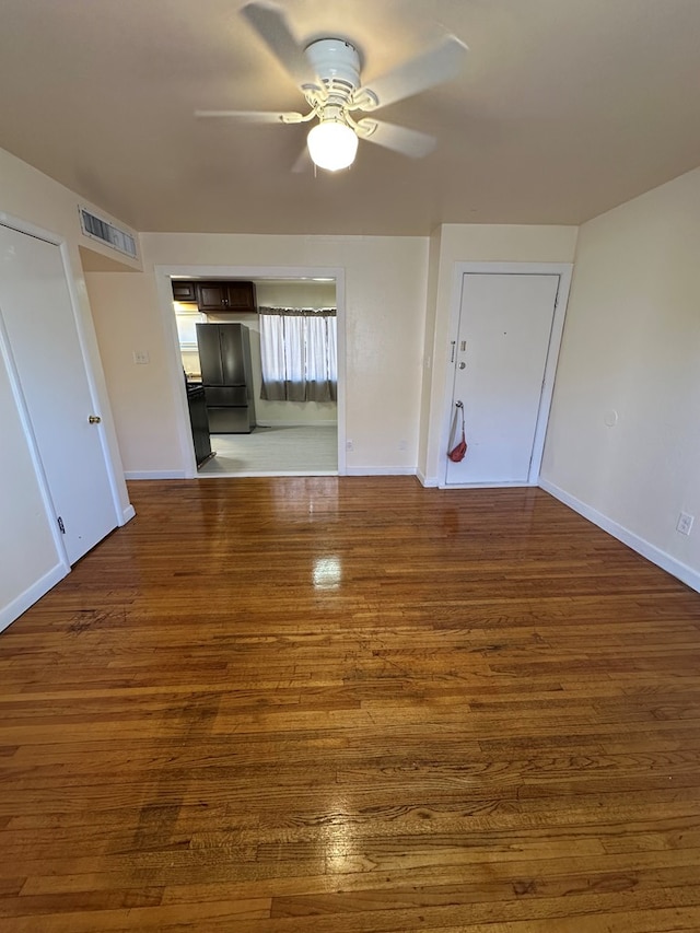 interior space with ceiling fan and dark hardwood / wood-style flooring