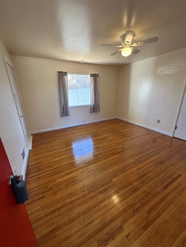 spare room featuring ceiling fan and dark wood-type flooring