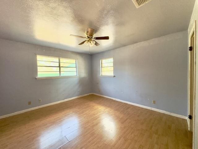 spare room with hardwood / wood-style floors, a textured ceiling, and ceiling fan