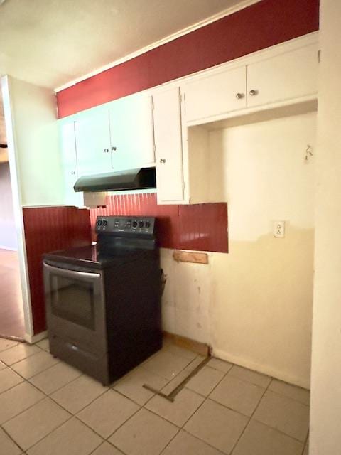 kitchen featuring white cabinetry, light tile patterned floors, and black electric range