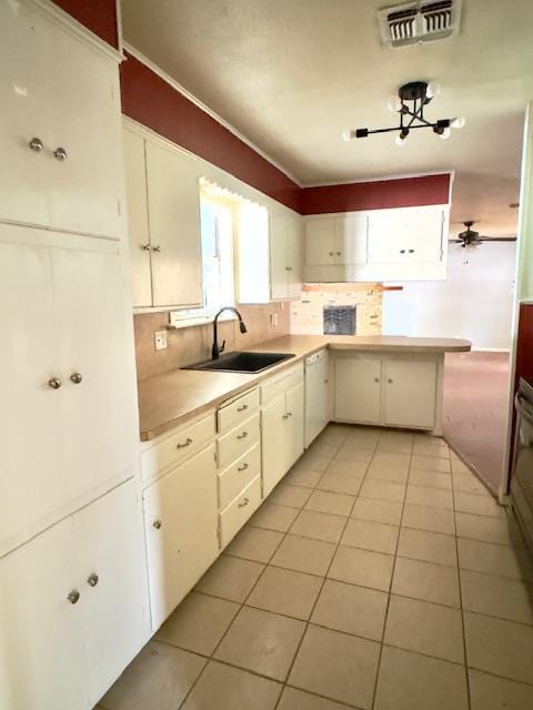 kitchen featuring tasteful backsplash, sink, white cabinets, and light tile patterned floors