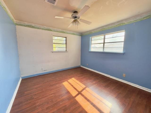 empty room with ceiling fan and dark hardwood / wood-style flooring