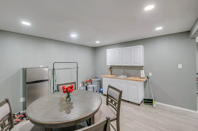 dining room featuring sink and light hardwood / wood-style flooring