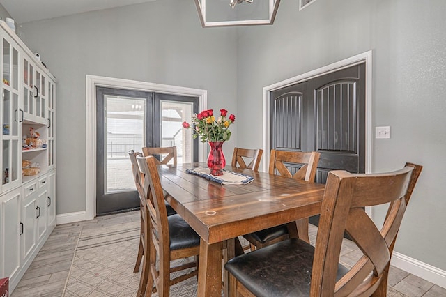 dining space with french doors and light hardwood / wood-style flooring