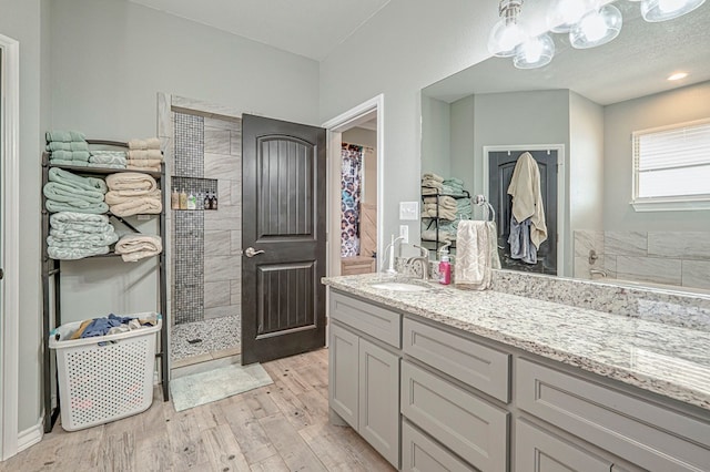 bathroom with vanity, wood-type flooring, and walk in shower